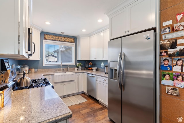 kitchen with recessed lighting, dark wood finished floors, a sink, white cabinetry, and appliances with stainless steel finishes