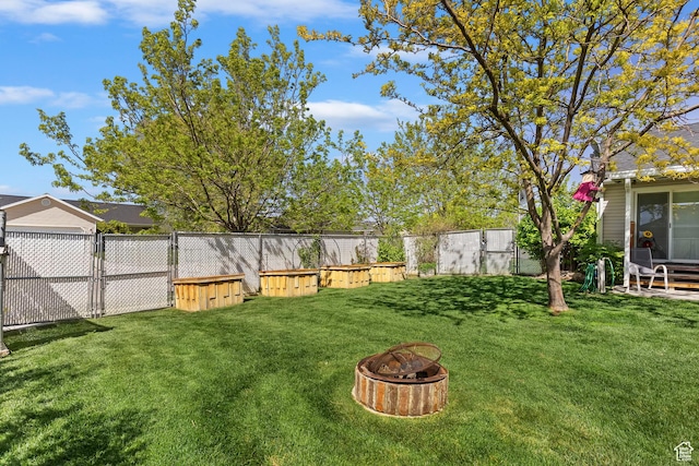 view of yard with a fenced backyard and a fire pit