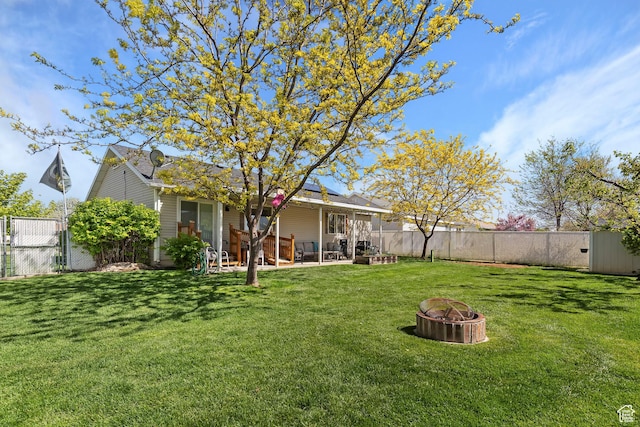view of yard featuring a fire pit, a patio area, and a fenced backyard