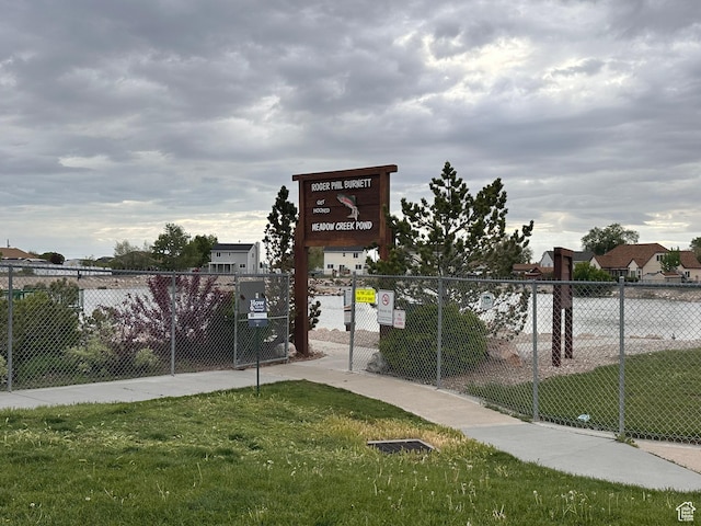 view of home's community with a yard and fence