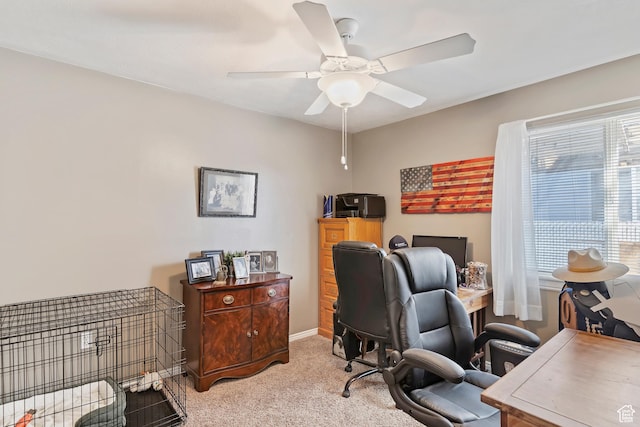 office area with light colored carpet, baseboards, and a ceiling fan