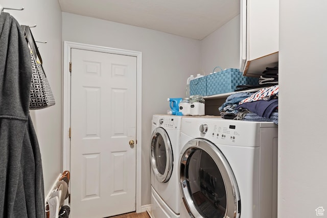 laundry area featuring separate washer and dryer and cabinet space