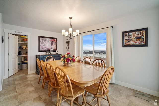 dining room with a notable chandelier, baseboards, and light tile patterned floors