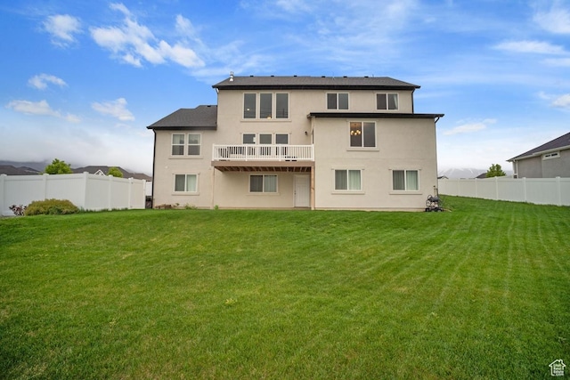 back of house featuring a yard, stucco siding, and a fenced backyard