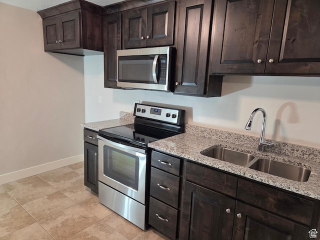 125 E Christley Ln, Elk Ridge, UT 84651 - kitchen featuring stainless steel appliances, a sink, baseboards, and light stone countertops
