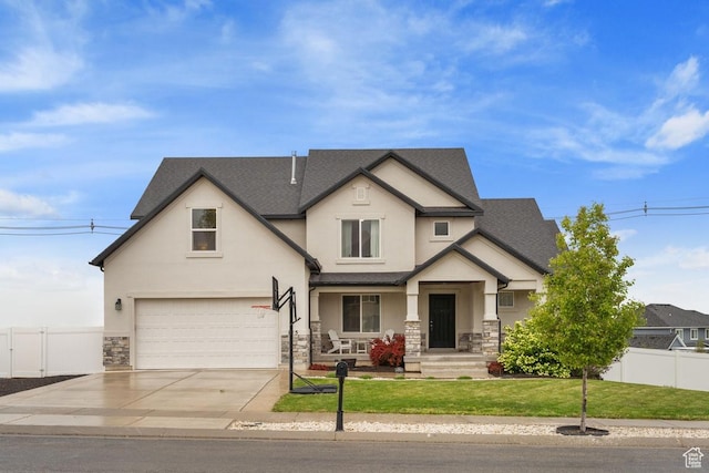 view of front of home with stone siding, stucco siding, fence, and a garage