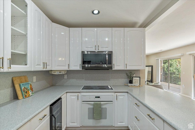 2568 S Elizabeth St Unit 5, Salt Lake City, UT 84106 - kitchen with stainless steel microwave, oven, wine cooler, white cabinets, and black electric cooktop