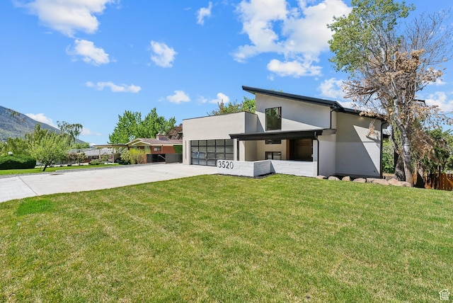 3520 S Westwood Dr E, Millcreek, UT 84109 - contemporary house featuring concrete driveway, stucco siding, an attached garage, and a front yard