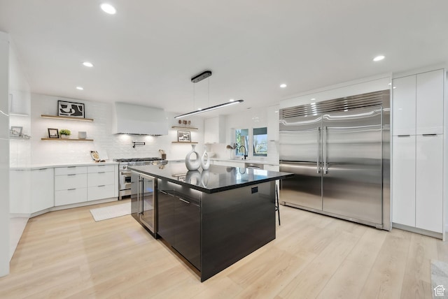 3520 S Westwood Dr E, Millcreek, UT 84109 - kitchen featuring extractor fan, white cabinets, premium appliances, modern cabinets, and light wood-style floors