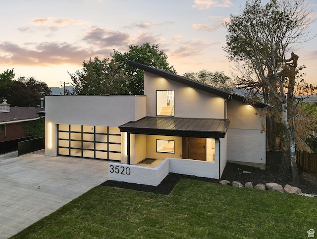 3520 S Westwood Dr E, Millcreek, UT 84109 - view of front of property featuring a lawn, a standing seam roof, metal roof, stucco siding, and concrete driveway