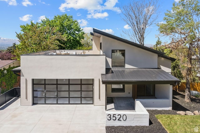 3520 S Westwood Dr E, Millcreek, UT 84109 - contemporary house with stucco siding, driveway, metal roof, and a porch