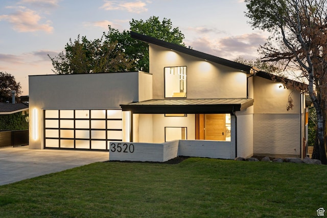 3520 S Westwood Dr E, Millcreek, UT 84109 - modern home with a garage, metal roof, concrete driveway, a front lawn, and a standing seam roof