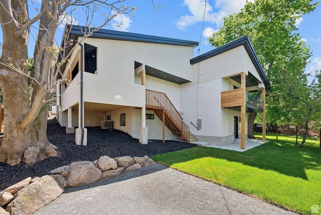 3520 S Westwood Dr E, Millcreek, UT 84109 - back of property featuring a yard, a patio, stucco siding, a carport, and cooling unit