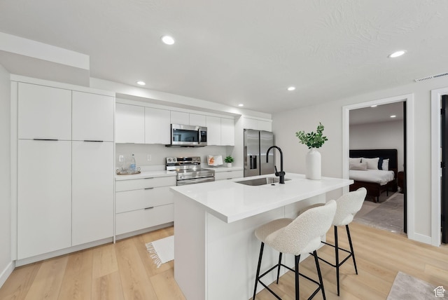 3520 S Westwood Dr E, Millcreek, UT 84109 - kitchen with a sink, stainless steel appliances, a kitchen breakfast bar, visible vents, and modern cabinets