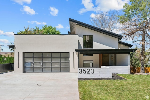 3520 S Westwood Dr E, Millcreek, UT 84109 - modern home with a front yard, a garage, stucco siding, and driveway