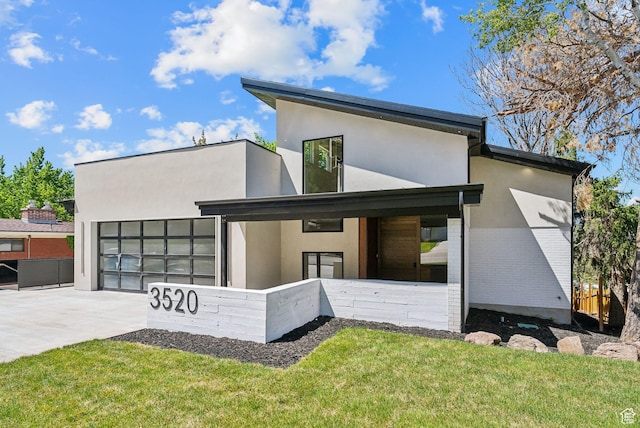 3520 S Westwood Dr E, Millcreek, UT 84109 - view of front of home with concrete driveway, an attached garage, stucco siding, and a front yard