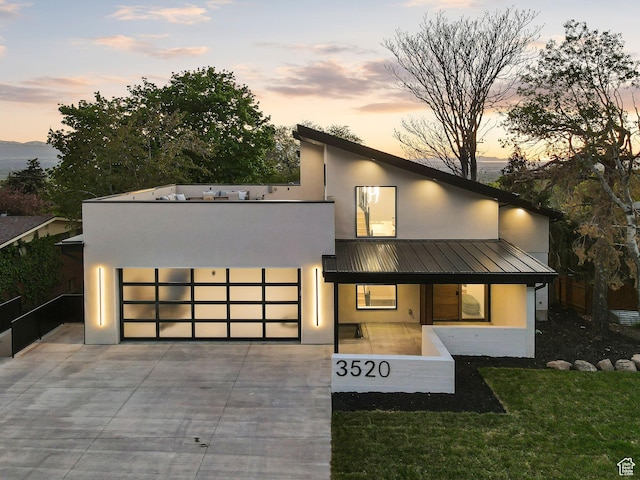 3520 S Westwood Dr E, Millcreek, UT 84109 - contemporary home featuring concrete driveway, metal roof, stucco siding, and an attached garage
