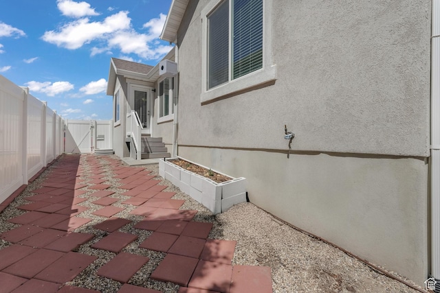 4999 W Tobago Ln, Herriman, UT 84096 - view of side of home with stucco siding, a gate, fence, and a patio area