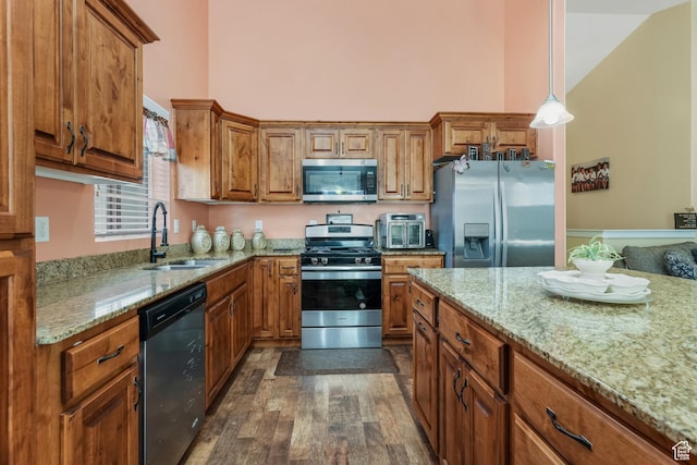 4999 W Tobago Ln, Herriman, UT 84096 - kitchen featuring a sink, brown cabinets, light stone countertops, and appliances with stainless steel finishes