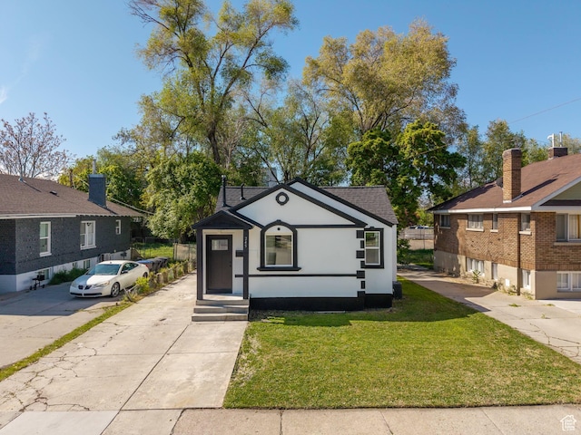 bungalow-style home with stucco siding and a front lawn