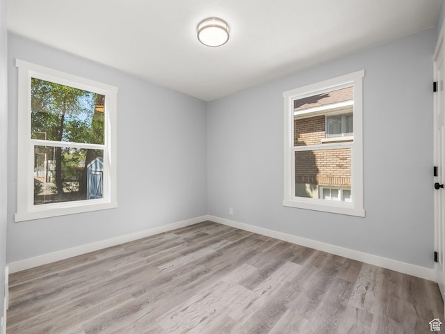 spare room featuring wood finished floors and baseboards