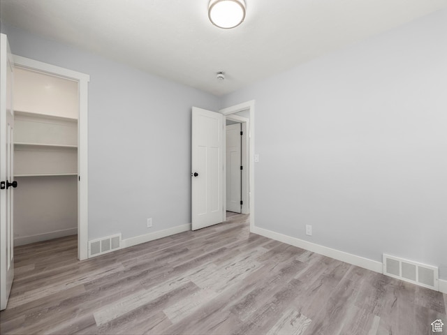 unfurnished bedroom featuring visible vents, wood finished floors, and baseboards