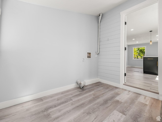 laundry area with laundry area, light wood-style floors, baseboards, and washer hookup