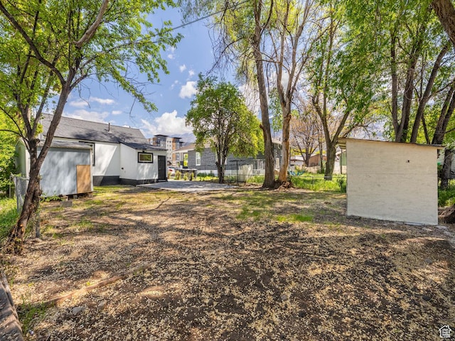 view of yard with an outdoor structure, a shed, and fence