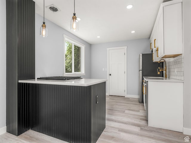 kitchen with light countertops, white cabinetry, and light wood-style flooring