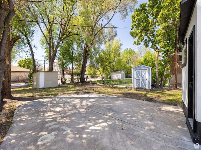 view of patio with a storage shed and an outbuilding