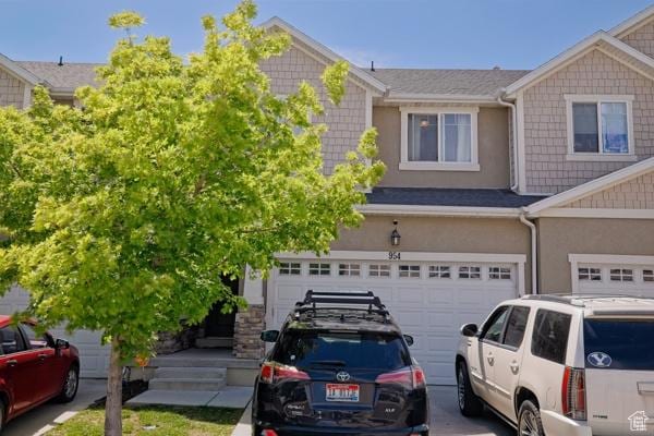 multi unit property with an attached garage and stucco siding