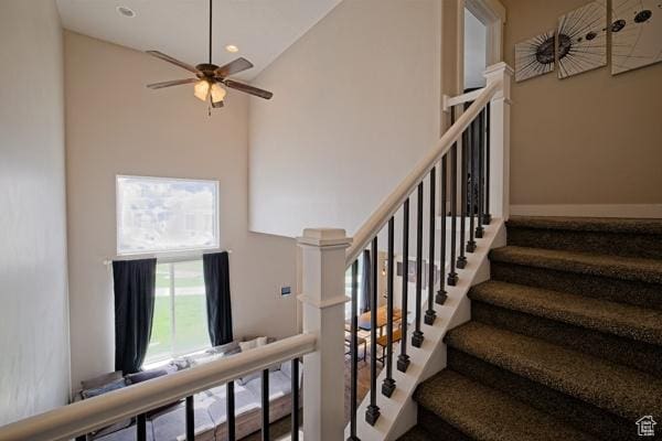stairs with high vaulted ceiling, a ceiling fan, and recessed lighting