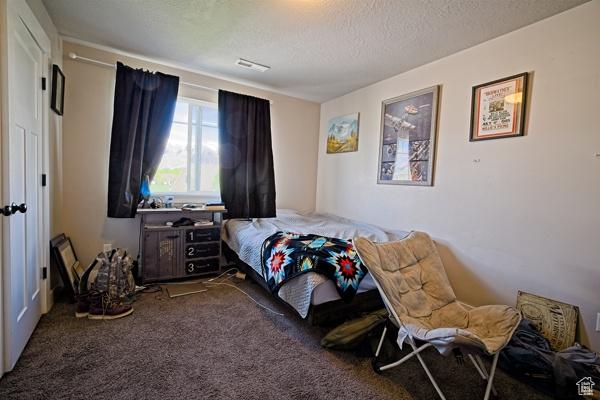 bedroom featuring a textured ceiling and carpet