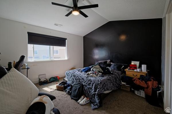 bedroom featuring lofted ceiling, ceiling fan, visible vents, and carpet floors