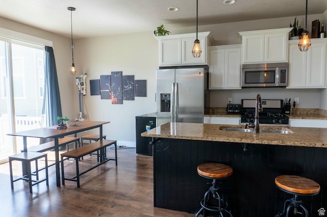 954 S 2040 W, Orem, UT 84059 - kitchen with appliances with stainless steel finishes, dark wood-style flooring, light stone countertops, white cabinetry, and a kitchen breakfast bar
