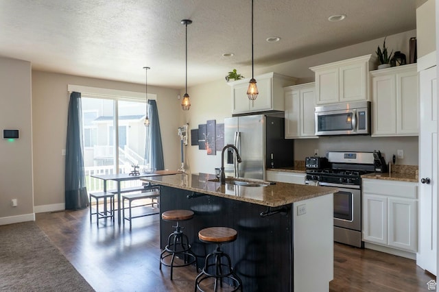 954 S 2040 W, Orem, UT 84059 - kitchen with stainless steel appliances, dark wood-style flooring, a kitchen island with sink, a kitchen bar, and a textured ceiling