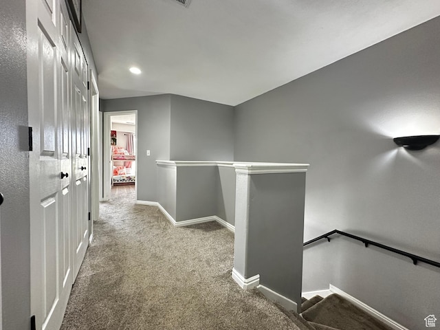 hall with recessed lighting, an upstairs landing, baseboards, and carpet floors