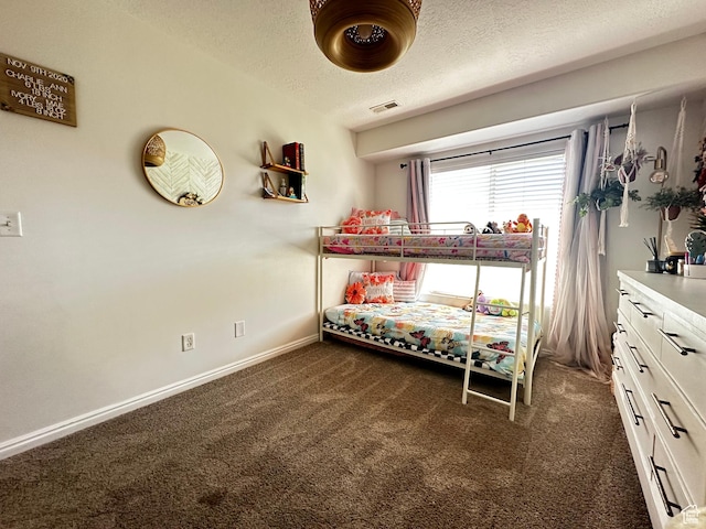 bedroom featuring baseboards, dark colored carpet, visible vents, and a textured ceiling