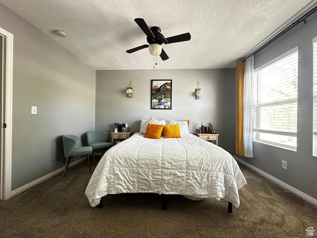 bedroom with a textured ceiling, carpet, baseboards, and a ceiling fan