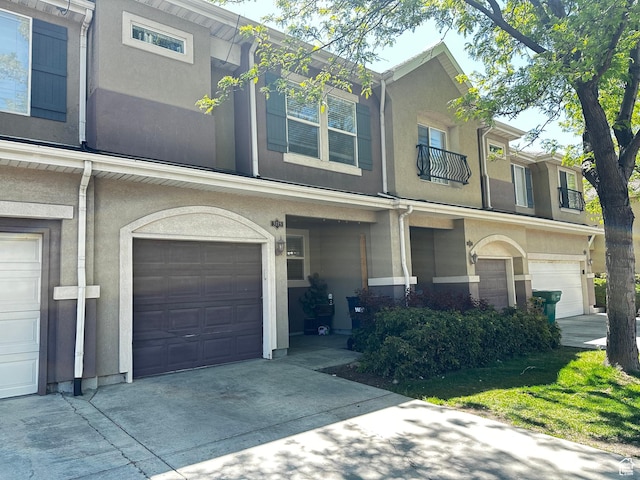 view of property featuring concrete driveway, stucco siding, and a garage