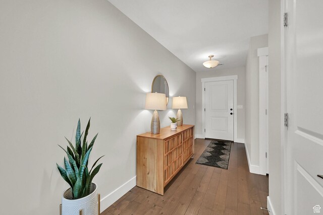 doorway to outside with baseboards and dark wood-style floors
