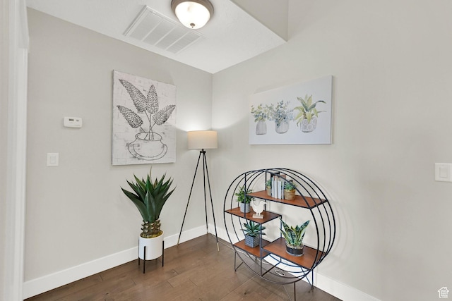 living area with baseboards, visible vents, and wood finished floors