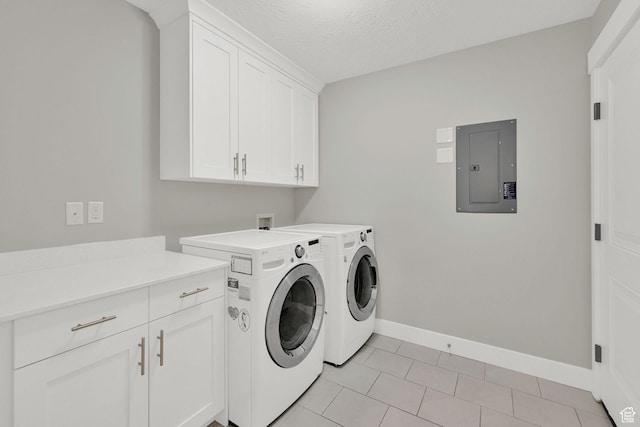 laundry room featuring electric panel, cabinet space, light tile patterned floors, washing machine and dryer, and baseboards