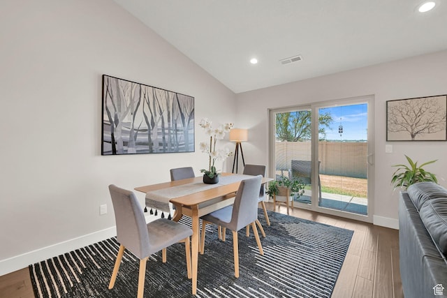 dining room featuring wood finished floors, visible vents, baseboards, lofted ceiling, and recessed lighting