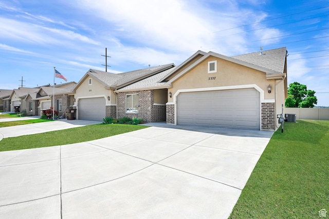view of front of home featuring an attached garage, concrete driveway, stucco siding, and a front yard