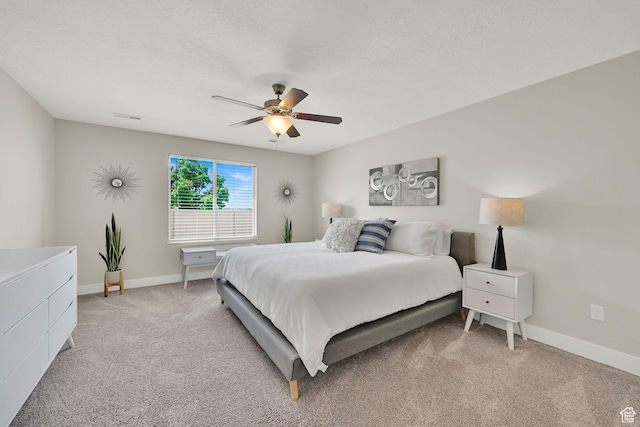 bedroom featuring light colored carpet, visible vents, baseboards, and a ceiling fan
