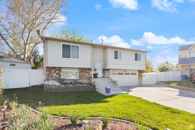 4990 S Hensley Cir, Taylorsville, UT 84129 - split foyer home featuring driveway, brick siding, fence, an attached garage, and a gate