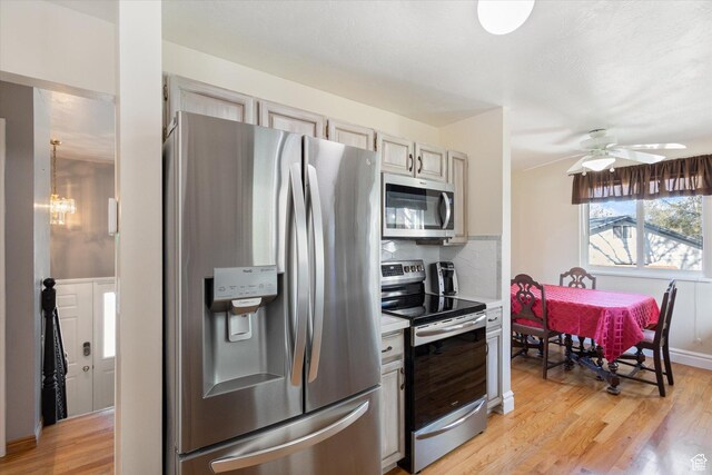 4990 S Hensley Cir, Taylorsville, UT 84129 - kitchen featuring stainless steel appliances, tasteful backsplash, ceiling fan with notable chandelier, light wood-type flooring, and light countertops