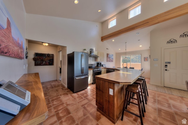 3686 S Spanish Valley Dr Unit K-2, Moab, UT 84532 - kitchen featuring freestanding refrigerator, dishwasher, range with gas stovetop, a breakfast bar, and wall chimney range hood
