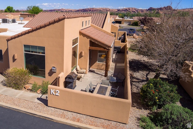 3686 S Spanish Valley Dr Unit K-2, Moab, UT 84532 - back of property with a tile roof, a patio area, stucco siding, and a mountain view